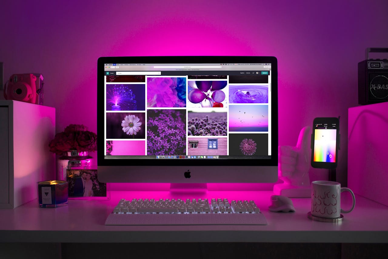 who-we-are Modern desk setup with neon lighting and a desktop computer displaying colorful images.